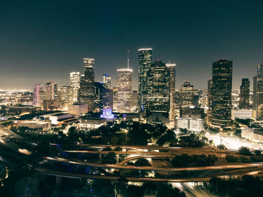 Stunning aerial view of Houston's illuminated skyline featuring skyscrapers and highways at night.