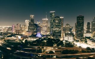 Stunning aerial view of Houston's illuminated skyline featuring skyscrapers and highways at night.