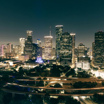 Stunning aerial view of Houston's illuminated skyline featuring skyscrapers and highways at night.