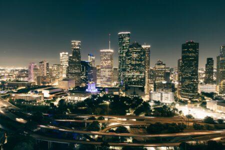 Stunning aerial view of Houston's illuminated skyline featuring skyscrapers and highways at night.